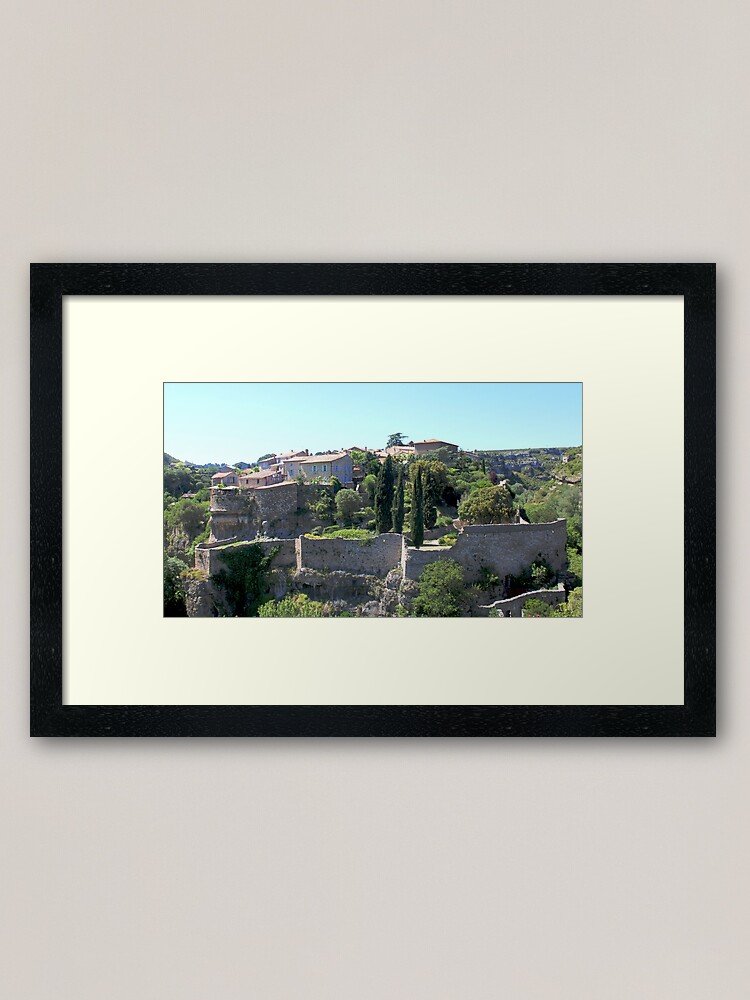 Set in the historic village of Minerve, this photograph captures a reconstructed medieval trebuchet standing proudly above ancient stone walls and Mediterranean vegetation. Minerve, once a Cathar stronghold, carries a powerful historical legacy. The trebuchet evokes the dramatic events of the 13th century, when the village endured siege and conflict during the Albigensian Crusade. Surrounded by cypress trees, rugged stone fortifications, and sunlit southern landscapes, the scene blends history, architecture, and natural beauty. This fine art print is ideal for: History lovers Medieval architecture enthusiasts Rustic or heritage-inspired interiors Travel and culture-themed spaces Printed in high quality to preserve the texture of stone, greenery, and the warm Mediterranean light.